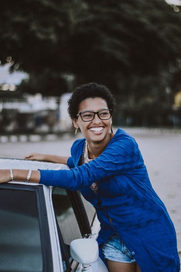 a woman leaning to her car